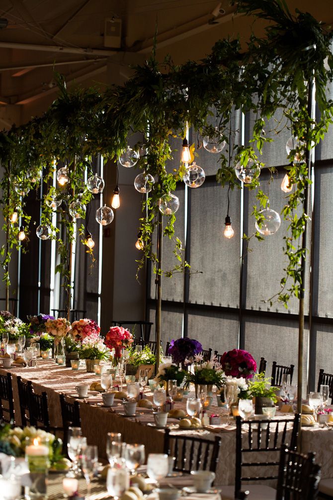 the tables are set up with flowers and greenery for an elegant dinner or party