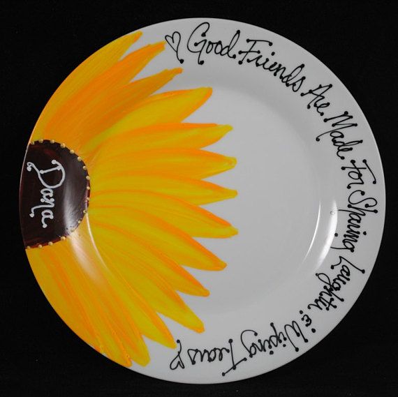 a sunflower painted on a white plate with writing