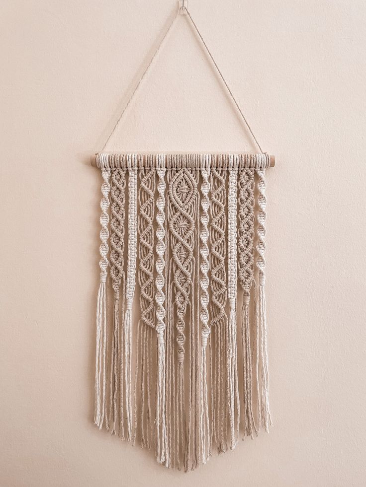 a macrame hanging on the wall with tassels