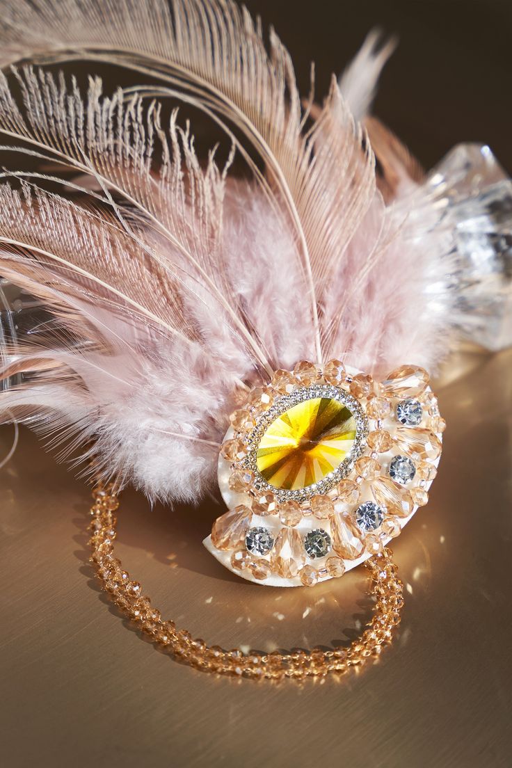 Roar back 100 years to unprecedented golden 20s with this headband, which perfectly create an elegant and sophisticated Gatsby style. Features: Crystal rhinestone chains High quality peacock feathers Beaded blossom pendant design Two-colored feather design Gold Feathered Wedding Jewelry, Gold Feather Jewelry For Wedding, Elegant Feather Jewelry For Evening, Elegant Evening Jewelry With Feathers, Gold Feathered Jewelry For Parties, Glamorous Party Jewelry With Feathers, Gold Elegant Headpiece For Mardi Gras, Elegant Gold Headpiece With Feathers, Elegant Beaded Headpieces For Gifts