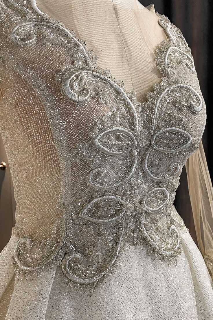 Luxurious light-reflecting true Beauty dress, covered in billions of sparkles and shiny details is what you need for your perfect wedding day. We are sure that Belle would choose this dress too, because it is absolutely princess-like and surely stunning. Fleur-de-lis motifs on the front are carefully hand-made, covering the V-lined décolleté to attract more attention. Our favorite detail of this dress is 2 different sleeves to choose from! See-through sparkly silver fabric on the sleeves adds so