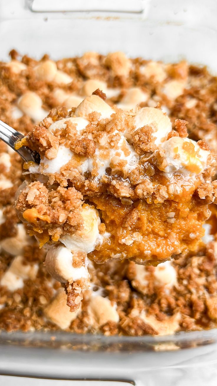 a close up of a spoon in a casserole dish with food on it