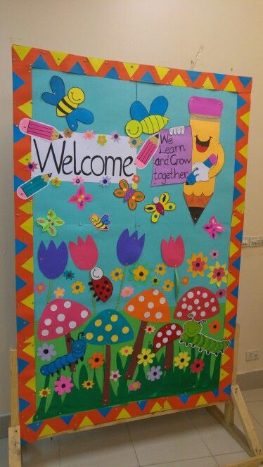 a welcome sign with flowers and bugs on it