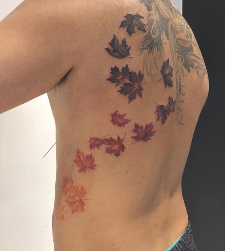 a woman's back with leaves on it and the bottom part of her body