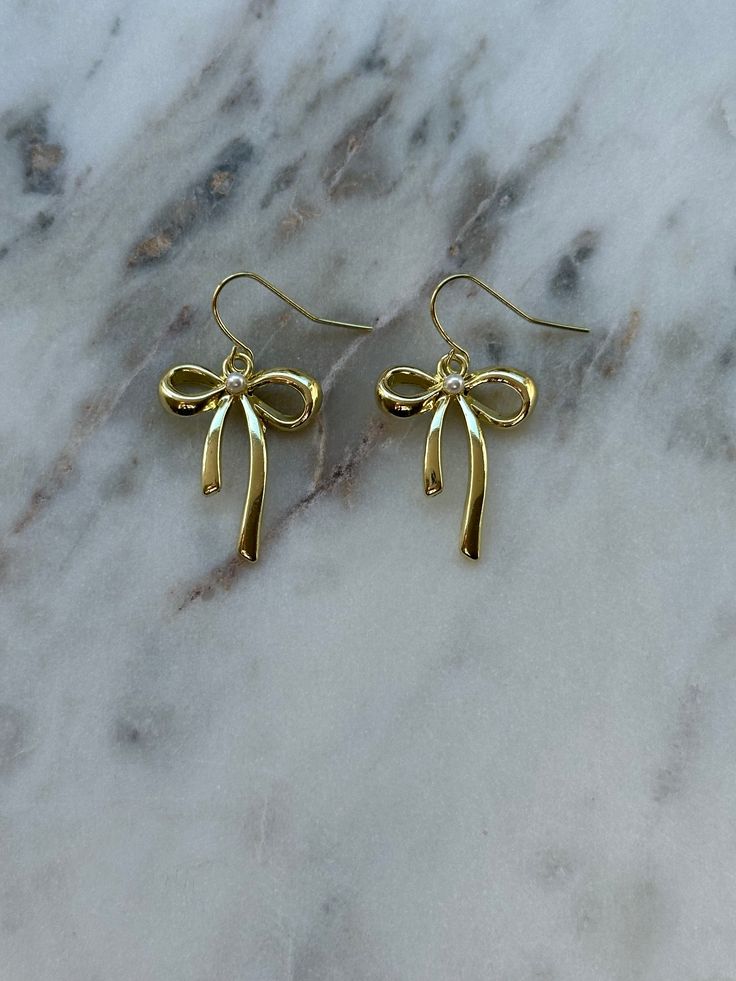 gold bow earrings – ivory moon Gold Jewelry Earings, Gold Earrings With Decorative Bow As Gift, Gold Earrings With Decorative Bow For Formal Occasions, Gold Dainty Bow Jewelry, Elegant Gold Earrings With Bow Tie Detail, Formal Gold Earrings With Decorative Bow, Dainty Gold Jewelry With Bow Detail, Dangle Bow Earrings For Gift, Gold Dangle Jewelry With Bow