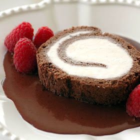 a chocolate dessert with cream and raspberries on a plate