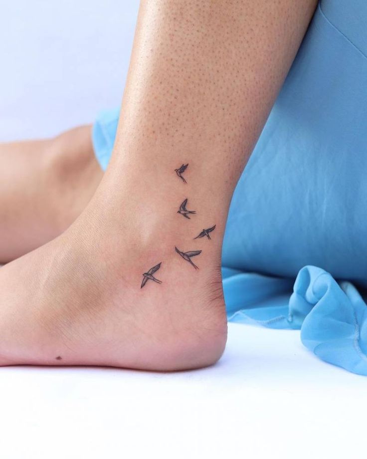 a woman's foot with three birds on it