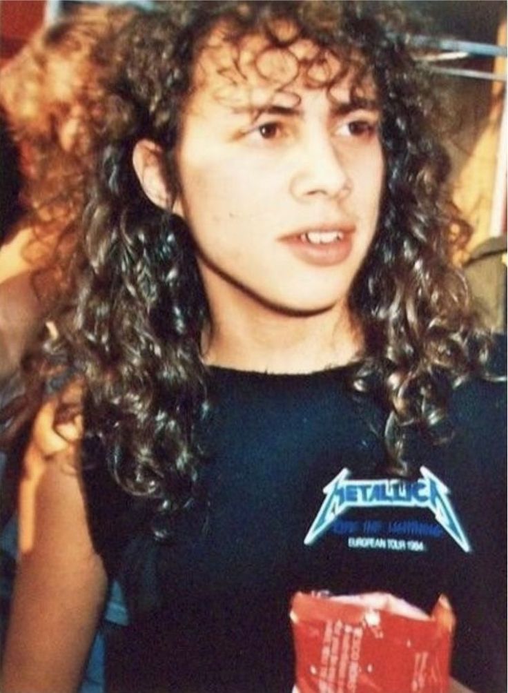 a young woman with curly hair holding a red box