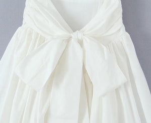 Lilly White Bow Tie Dress – Juniper Summer Wedding Dress With Bow Tie Back, Chic Bow Print Summer Dress, White Summer Dress With Bow Tie Back, Spring Beach Dress With Bow Detail, Spring Beach Dress With Bow, Chic Spring Dress With Bow Tie, Elegant Bow Print Dresses For Spring, White Sleeveless Dress With Bow, White Vacation Dress With Bow Detail