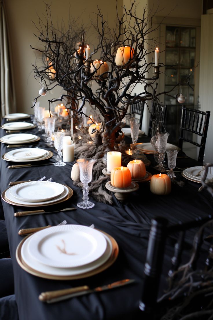 a table set with candles, plates and place settings for an elegant halloween dinner party