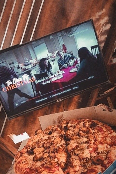 a pizza sitting on top of a table next to a tv