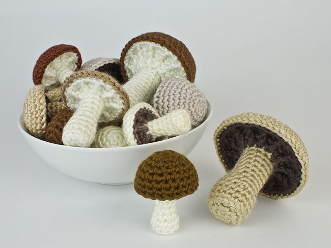 crocheted mushrooms are in a white bowl