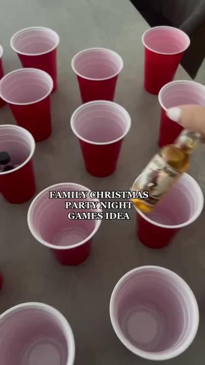 a person is picking up a drink from red cups with the words family christmas party night games idea