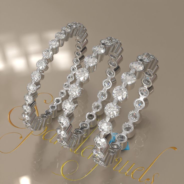 three diamond bracelets are shown on a table with the word love spelled below them