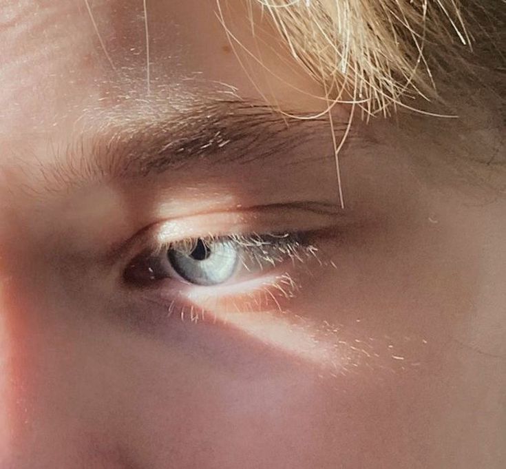 a close up of a person's face with the sun shining on their eyes