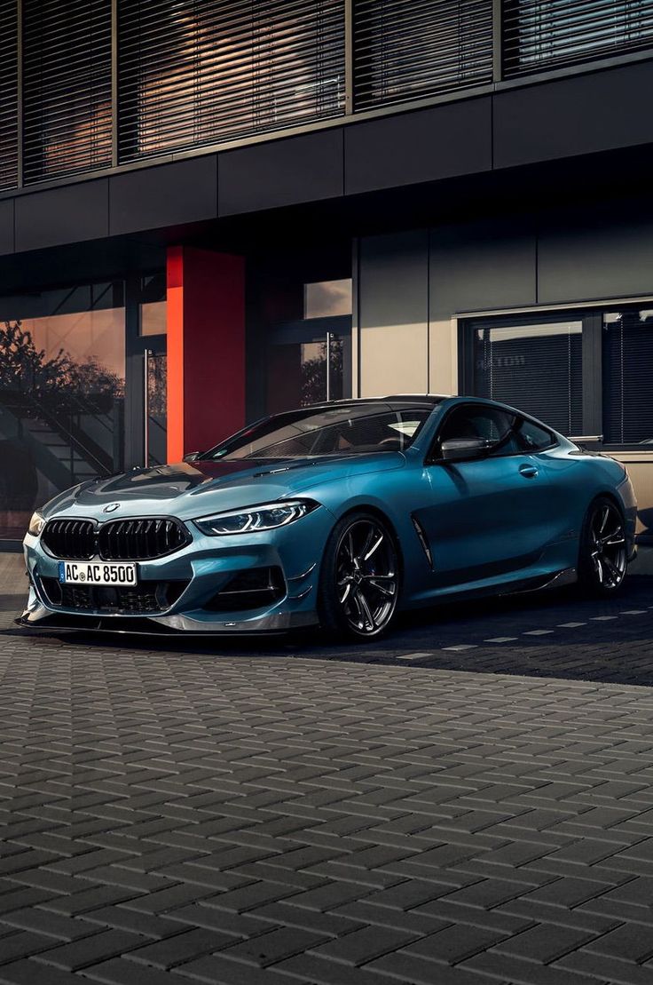 a blue bmw car parked in front of a building