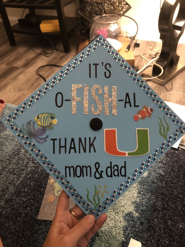 a blue graduation cap that says it's o - fish all thank mom and dad