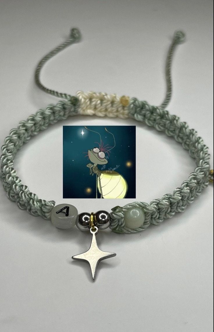 a bracelet with a star charm and two charms attached to the clasp, on a white background