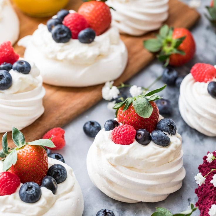 small desserts with whipped cream and fresh berries on the top are ready to be eaten