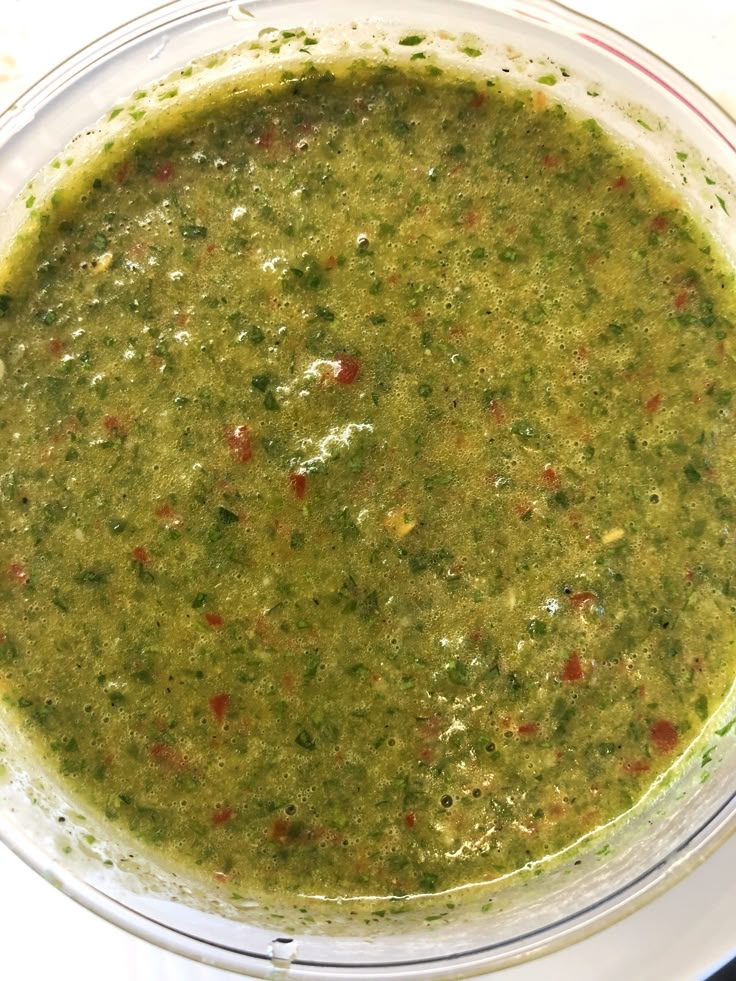 a bowl filled with green soup sitting on top of a table