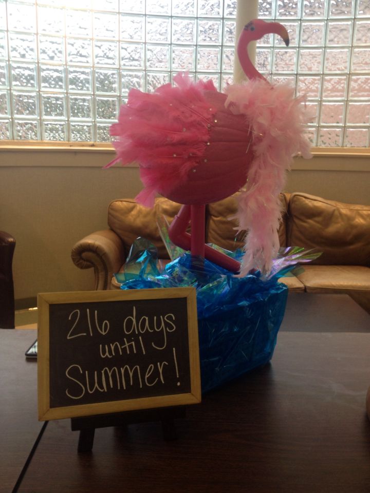 a pink flamingo sitting on top of a table next to a sign that says, 24 days until summer