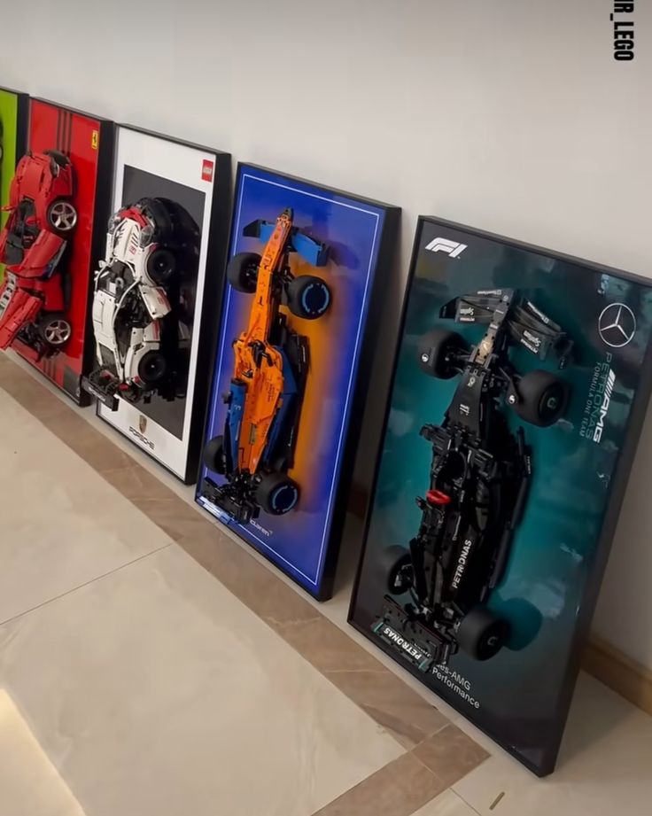 a row of framed race cars sitting on top of a white floor next to each other