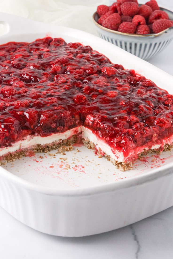 a dessert dish with raspberry cheesecake in the middle and berries on the side