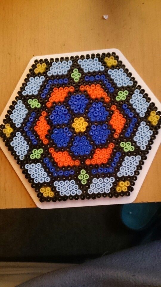 a beaded coaster sitting on top of a wooden table