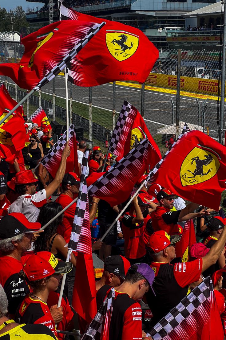 ferrari fans wave their flags in the paddock