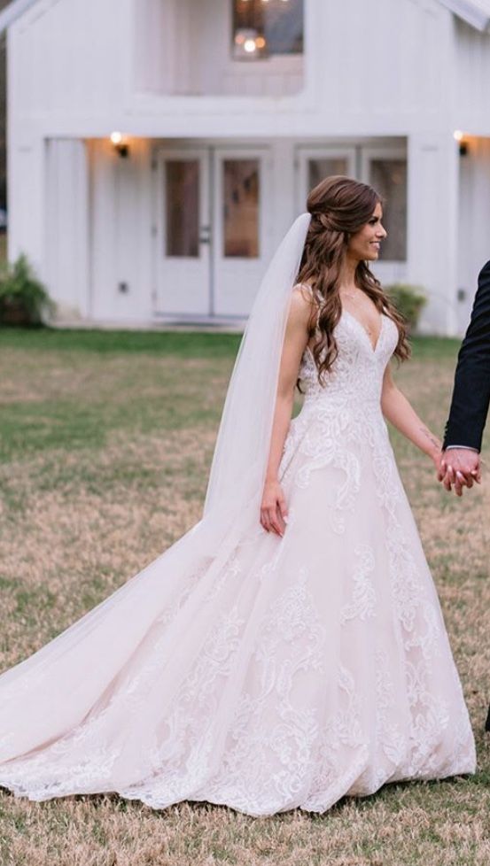 a bride and groom holding hands in front of a white house