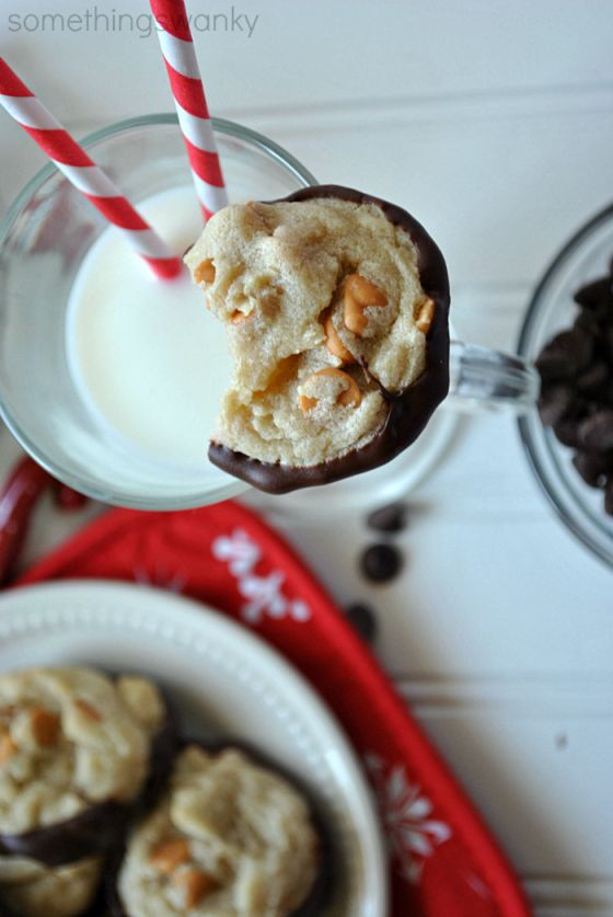 chocolate covered cookies and milk are sitting on a red napkin next to two glasses of milk