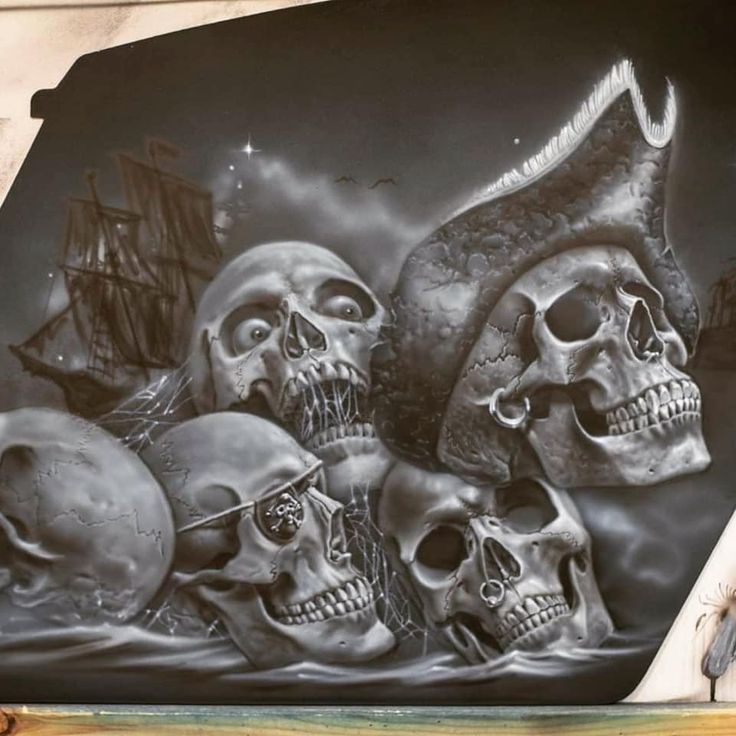 there are many skulls on the side of this wall painted with black and white paint