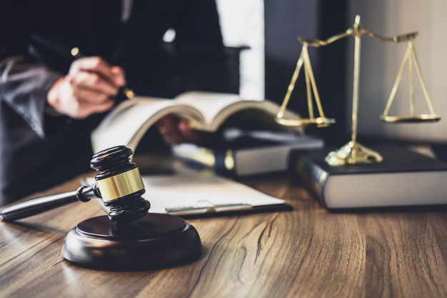 a judge's gavel sitting on top of a wooden table next to an open book