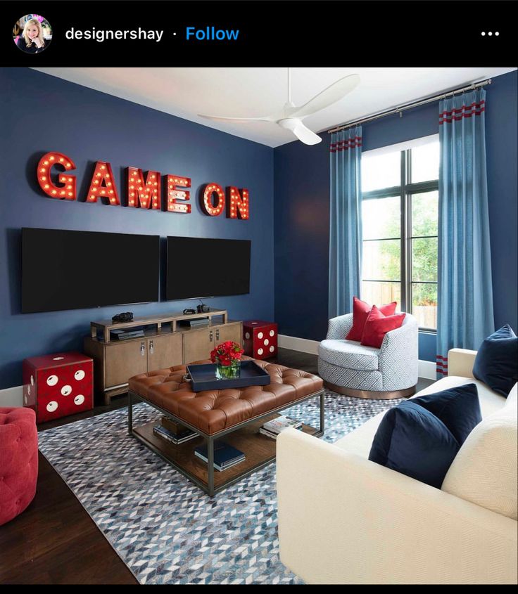 a living room filled with furniture and a large sign on the wall above it that says game on