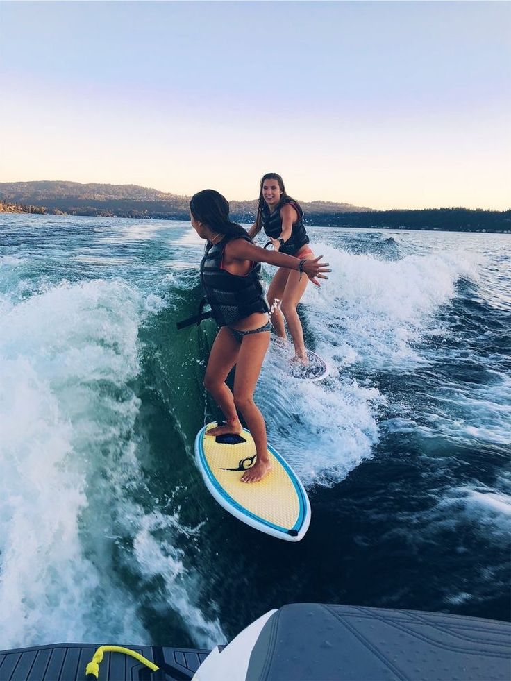 two women on surfboards in the water