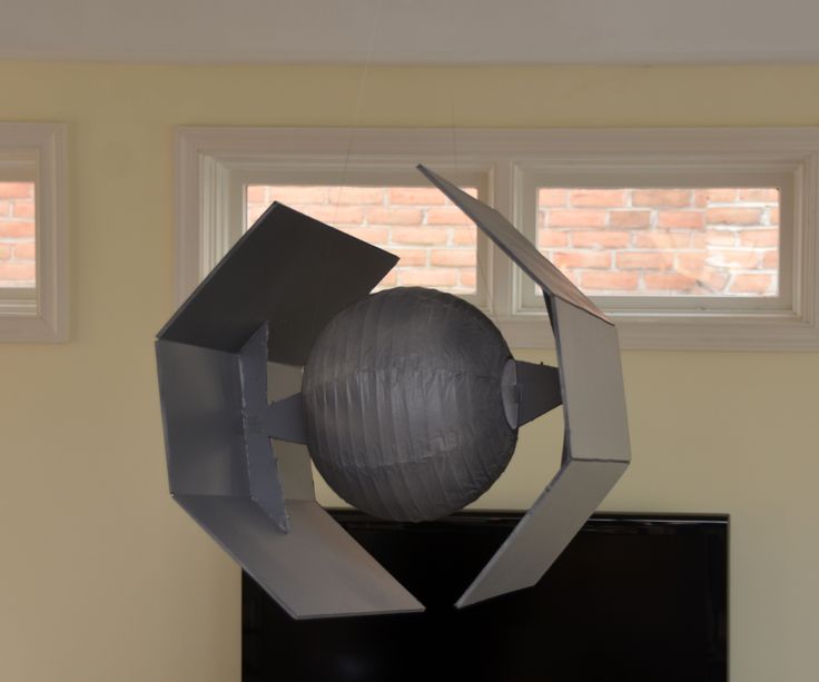 a large metal object sitting on top of a black cabinet in front of a window