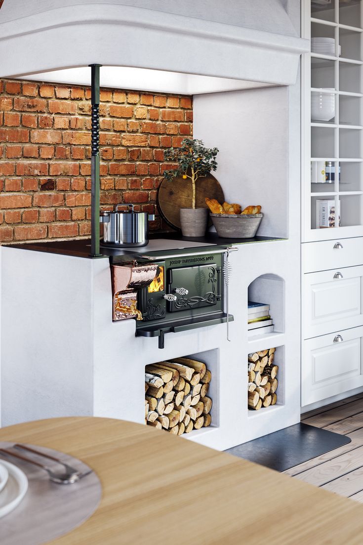 an oven in the middle of a kitchen with wood stacked on it's sides