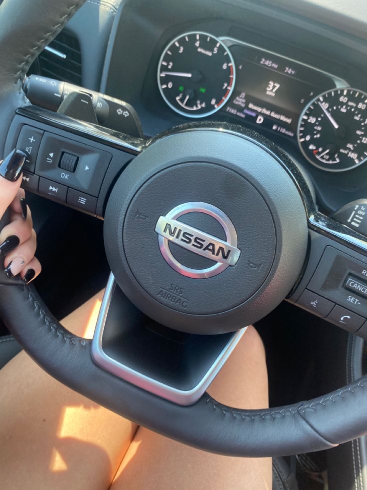 a woman is sitting in the driver's seat of a car with her feet on the steering wheel