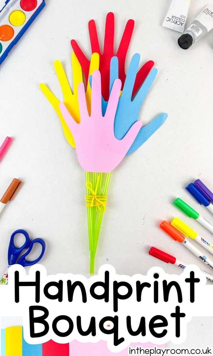 a bunch of colorful handprints sitting on top of a table with scissors and markers