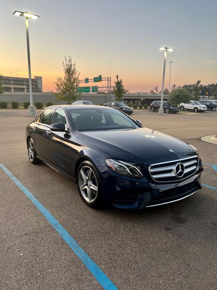 a blue mercedes benz s - class parked in a parking lot at sunset or dawn