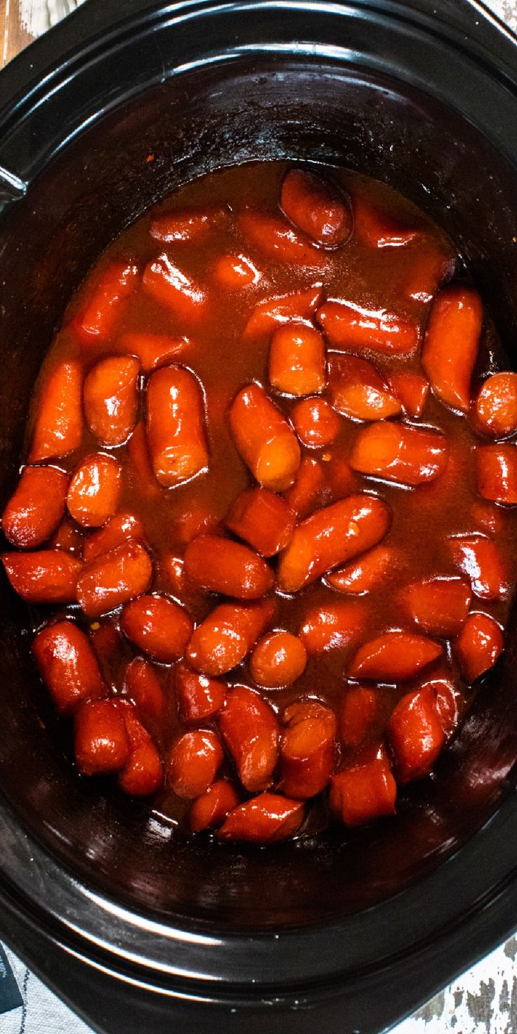 a crock pot filled with cooked carrots and sauce