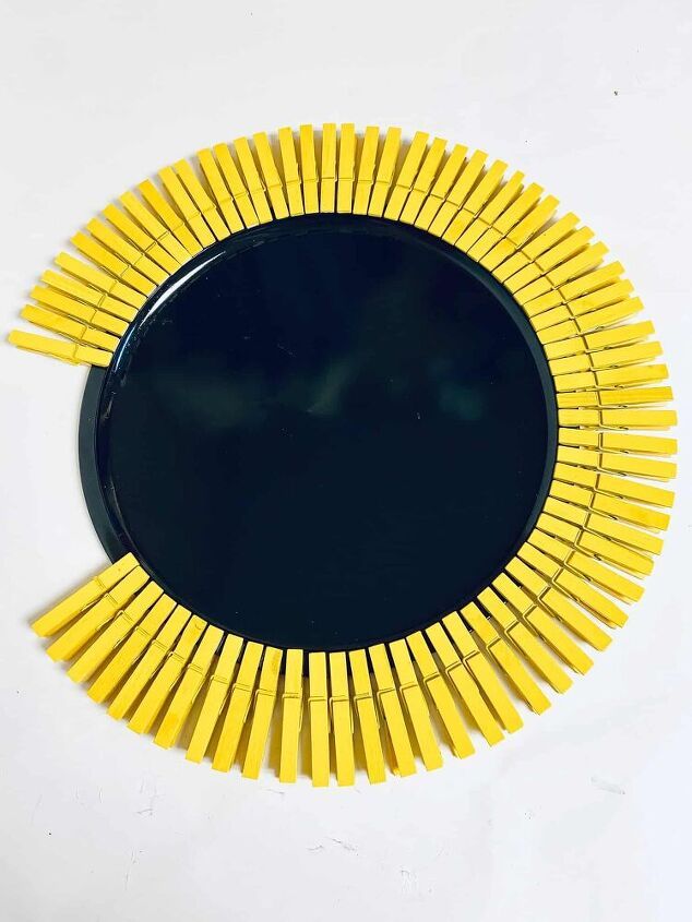 a black plate with yellow sticks in the shape of a sunburst on it