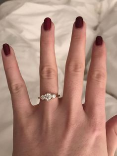 a woman's hand with a three stone ring on top of her left hand