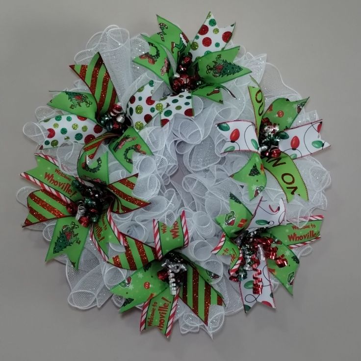 a christmas wreath made out of mesh and ribbon with candy canes on the top