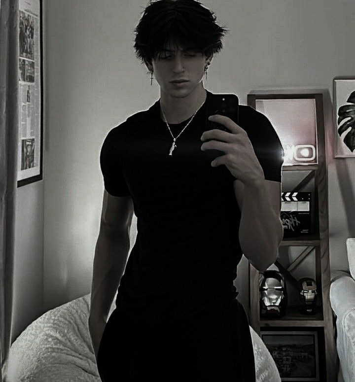 a young man is taking a selfie in the mirror while wearing a black dress