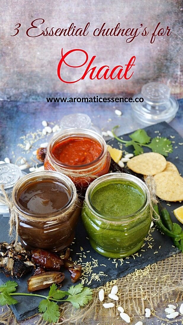 three jars filled with different types of sauces on top of a table next to crackers