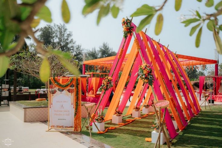 an orange and pink tent set up for a wedding