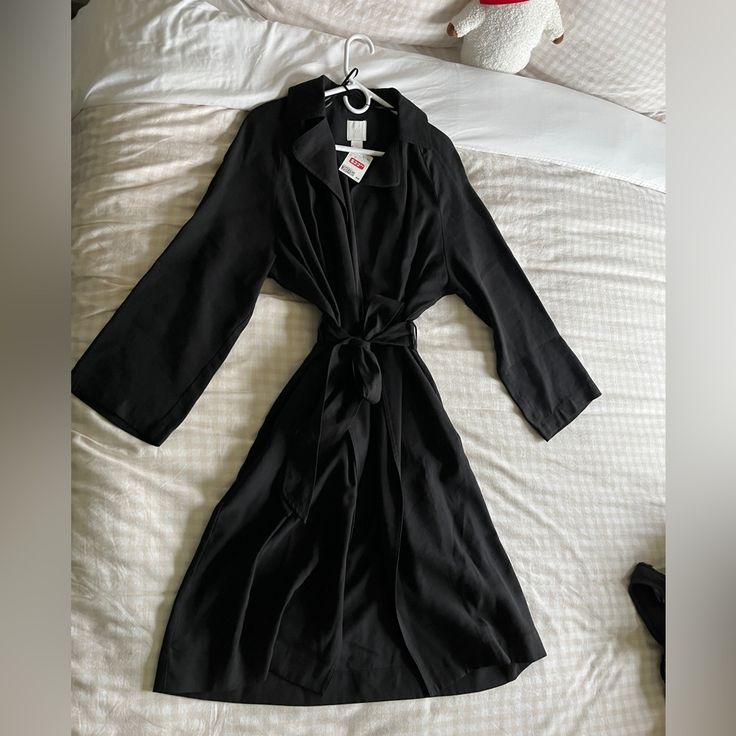 New With Tag H&M Black Trenchcoat. Made With Light Weight Fabric So Can Wear And Layer All Season Long. Bought This During A Phase But Never Got To Use It. Has 2 Pockets In The Front, Elastic Waist In The Back, Has A Tie Belt, Wide Cut Sleeves. Size Small. About 40 Inches Long. New Condition! No Visible Flaws! Solid Open Front Outerwear For Work, H&m Black Long Sleeve Outerwear, Belted Long Sleeve Outerwear For Daywear, H&m Long Sleeve Winter Blazer, H&m Winter Blazer, H&m Black Outerwear For Work, H&m Black Workwear Outerwear, H&m Fall Office Outerwear, H&m Long Sleeve Outerwear For Work