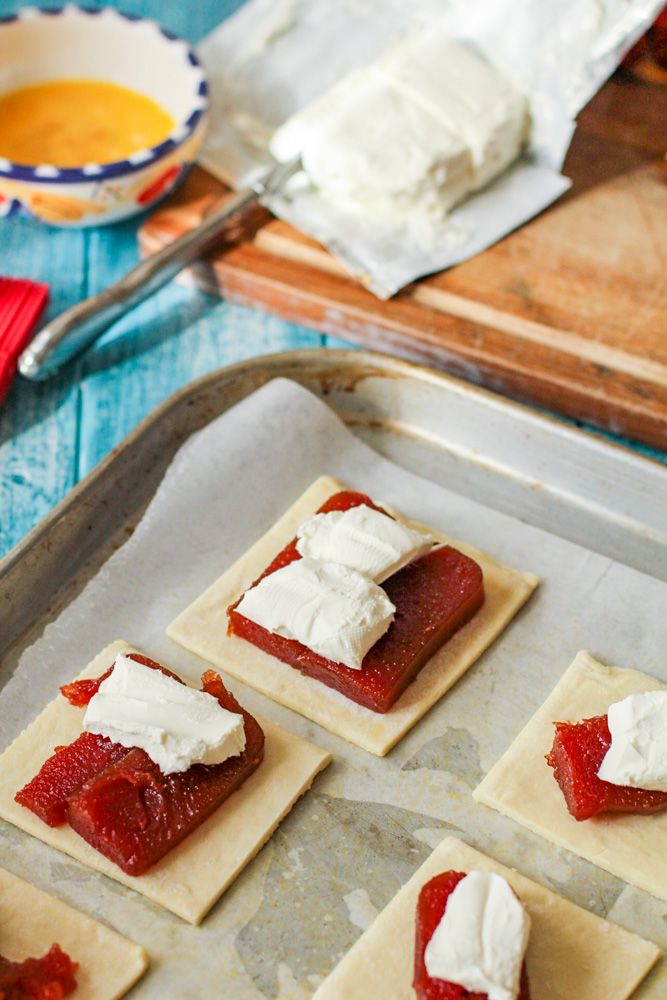 small pastries with cream cheese and strawberry jam on them are ready to go into the oven