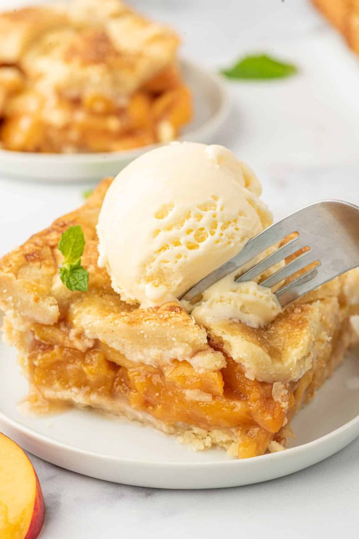 a piece of pie with ice cream on top and two plates full of peaches